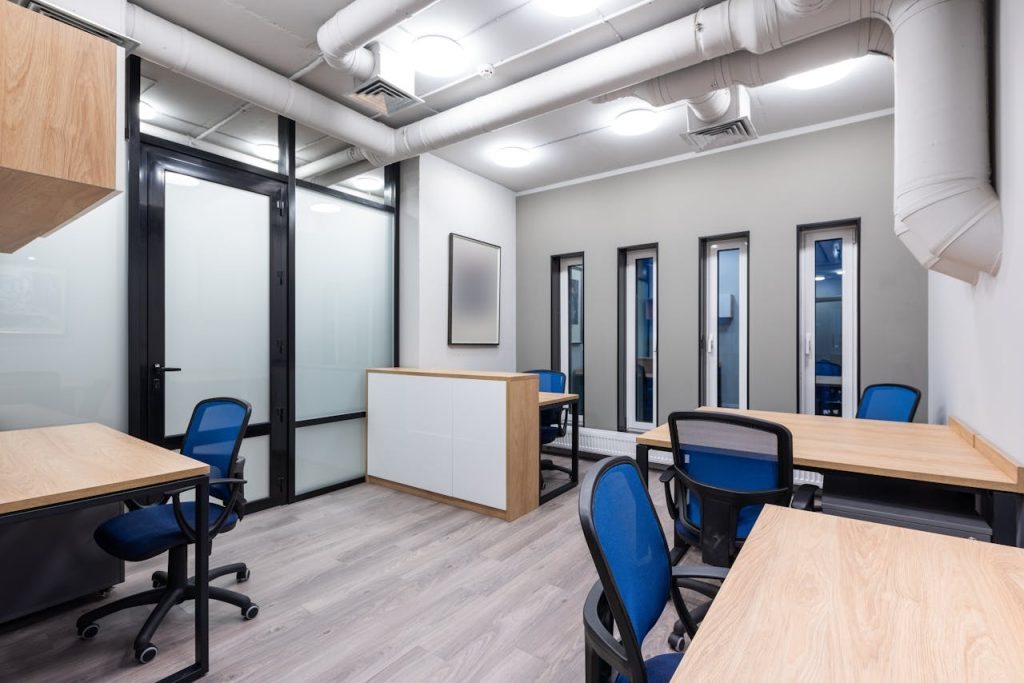 Interior of new contemporary spacious workplace with wooden desks and blue office chairs